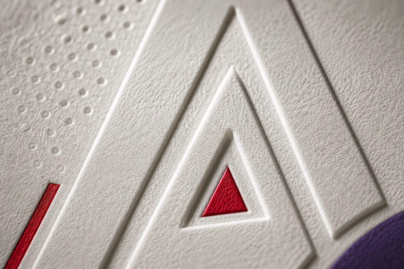 Macro d'un monogramme S gaufré en relief sur un papier blanc texturé